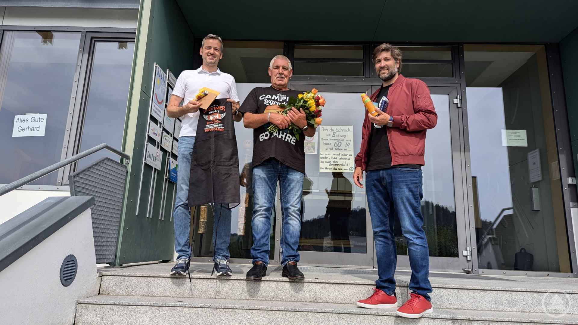 Schulleiter Ferdinand Klingelhöfer und Personalratsvorsitzender Robert Helm gratulierten Gerhard Siegl vor den dekorierten Fenstern der Realschule.