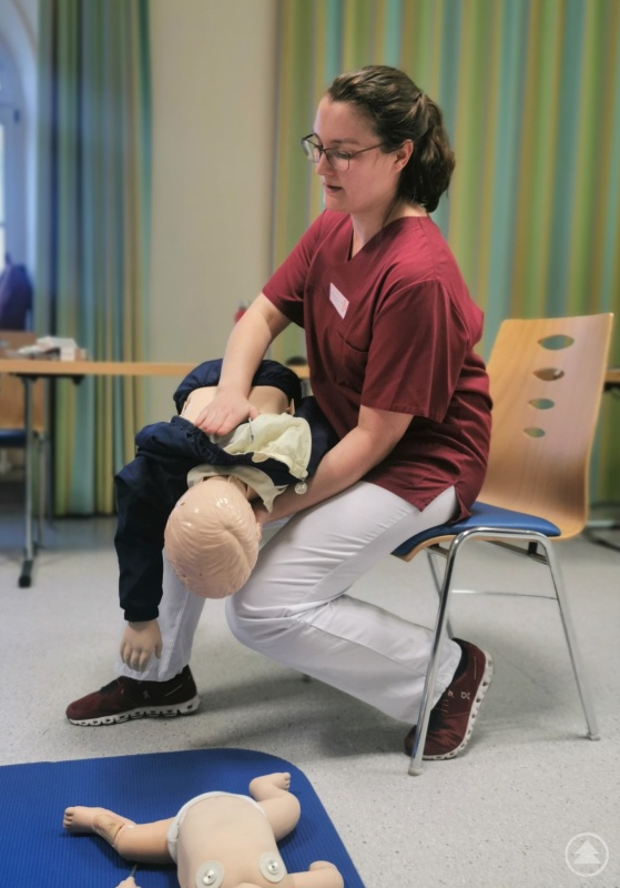 Dr. Nele Schultheis, Fachärztin für Kinder- und Jugendmedizin an der Kinderklinik Dritter Orden Passau, erklärt Eltern wichtige Handgriffe beim Erste-Hilfe Kurs bei Kindernotfällen.