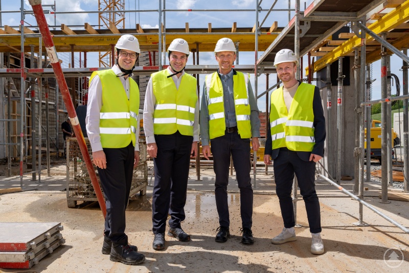 Bürgermeister Martin Pichler (v.l.), Landrat Sebastian Gruber, COO Stefan Feldmeier und Wirtschaftsreferent Johannes Gastinger im Bereich der künftigen Kantine. Darüber wird dann die moderne Fertigung auf nächsthöherer Geländeetage entstehen. Foto: Sesotec